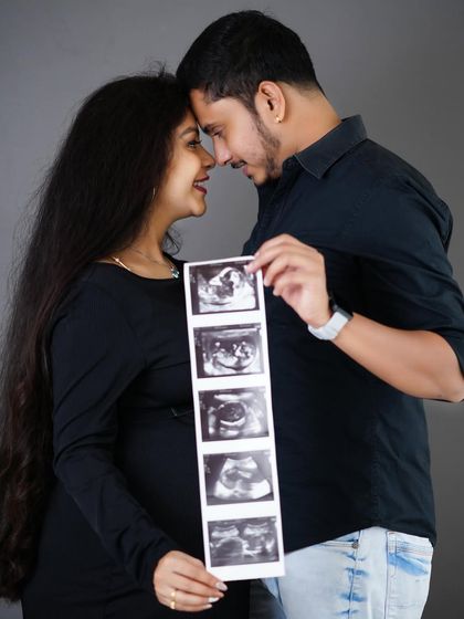 A close, intimate portrait of an expecting couple holding their baby's ultrasound scans, a beautiful way to include their little one in the maternity shoot.
