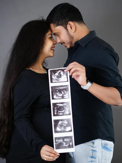 A close, intimate portrait of an expecting couple holding their baby's ultrasound scans, a beautiful way to include their little one in the maternity shoot.