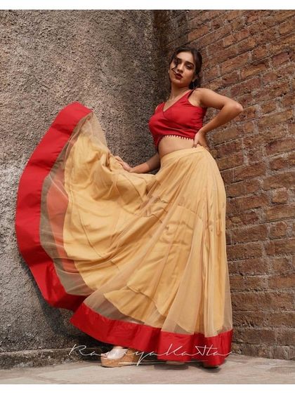 A simple yet stunning beige tulle skirt paired with a vibrant red tie-back crop top. The movement of the skirt makes it a joy to wear.