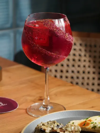 A close-up of a sparkling red cocktail, perfectly garnished. This shot is all about capturing the refreshment and visual appeal of the drink.