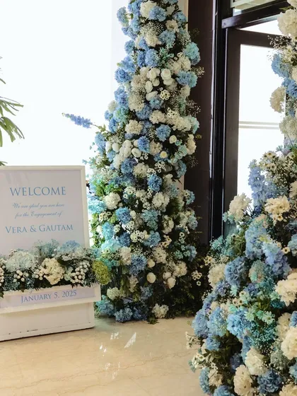 A stunning floral arch of blue and white hydrangeas welcomes guests to the engagement party, setting a fresh and elegant tone from the moment they arrive.