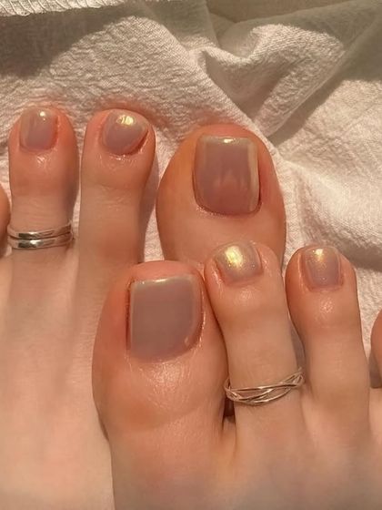 A neutral-toned holochrome pedicure, perfect for a subtle and chic look.