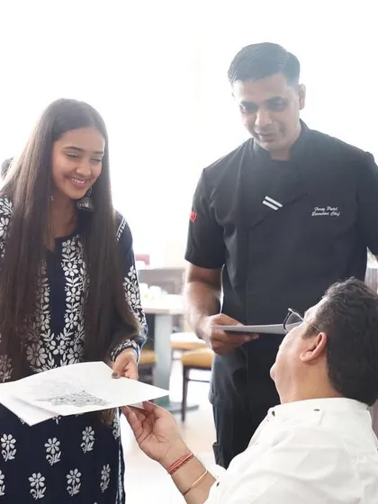 Showing a finished example to a participant. Visual aids and one-on-one interaction are part of how I guide everyone through the creative process.