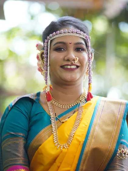A close-up portrait of the bride, showing the details of her mundavalya and the soft, blended eyeshadow.