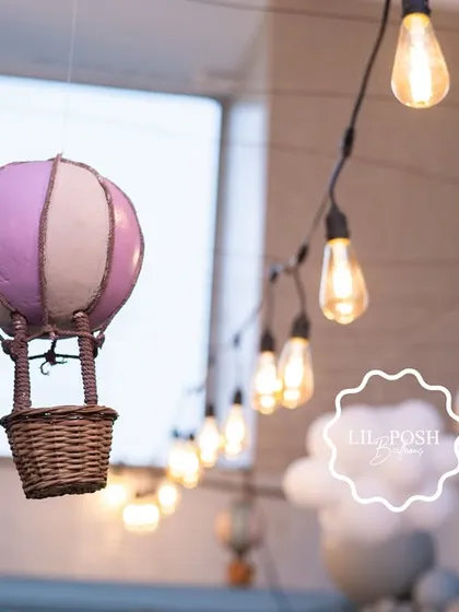 A tiny hot air balloon hangs from the ceiling, part of a collection that created a dreamy, floating effect above the baby shower.