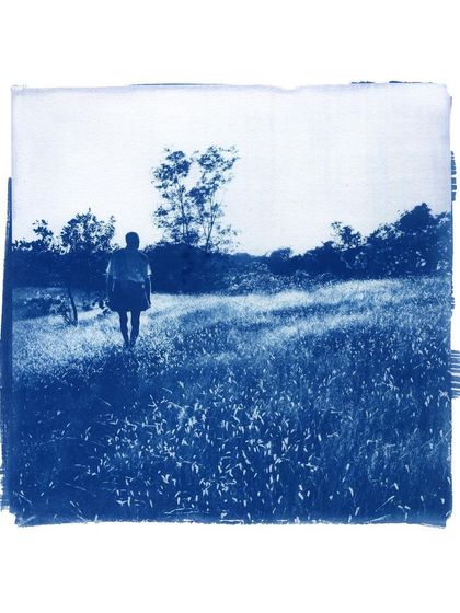 A solitary figure in a field, captured in the rich blue of a cyanotype. This process, also known as sun printing, gives images a timeless, almost dreamlike quality.