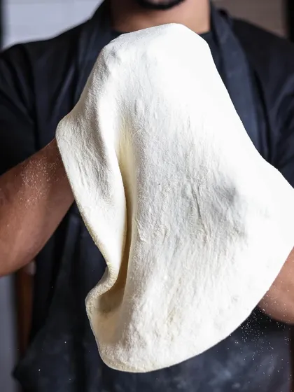 Prepping your pizzas. The dough is expertly tossed and stretched to achieve the perfect thinness.