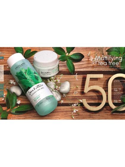 An ingredient-focused flat lay for the Love Nature Mattifying Tea Tree line. The products are styled on a wooden surface with fresh tea tree leaves to visually communicate their natural formulation.