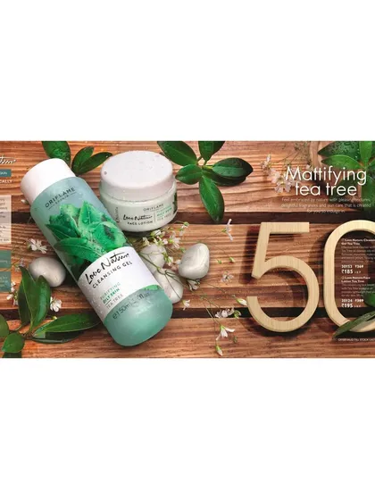 An ingredient-focused flat lay for the Love Nature Mattifying Tea Tree line. The products are styled on a wooden surface with fresh tea tree leaves to visually communicate their natural formulation.