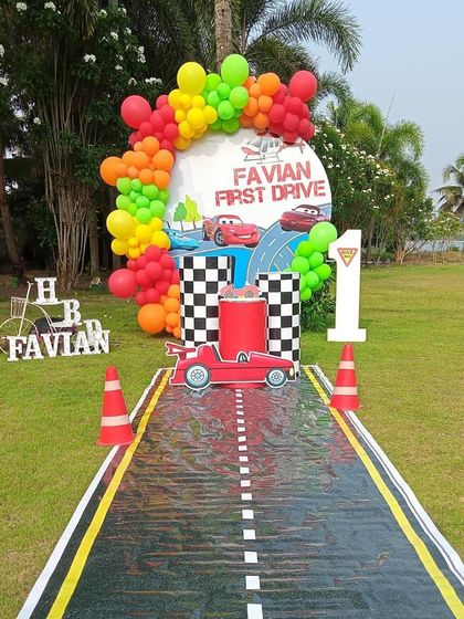 For a 'First Drive' birthday, I created this fun race car theme with a road-style entrance, traffic cones, and a colorful balloon arch.