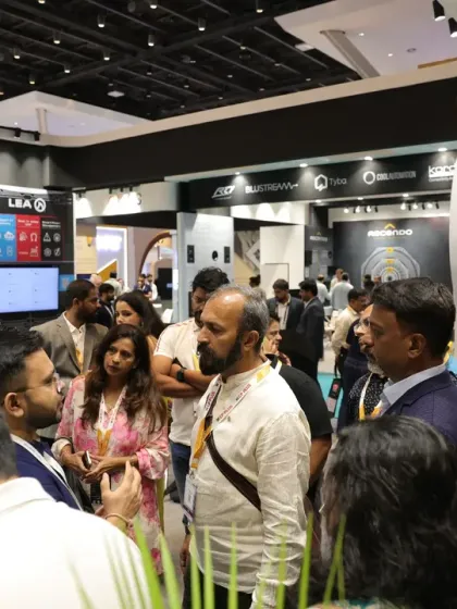 A crowd gathers at a booth showcasing slim in-wall/ceiling speakers, demonstrating the high level of interest in discreet and high-performance AV solutions.