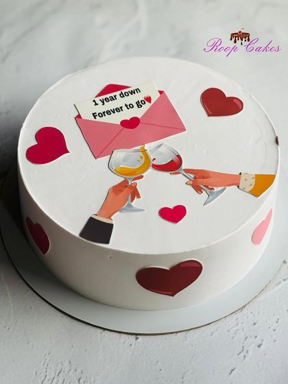 A simple yet sweet anniversary cake. This design features a romantic toast, hearts, and a love letter that says "1 year down, forever to go."