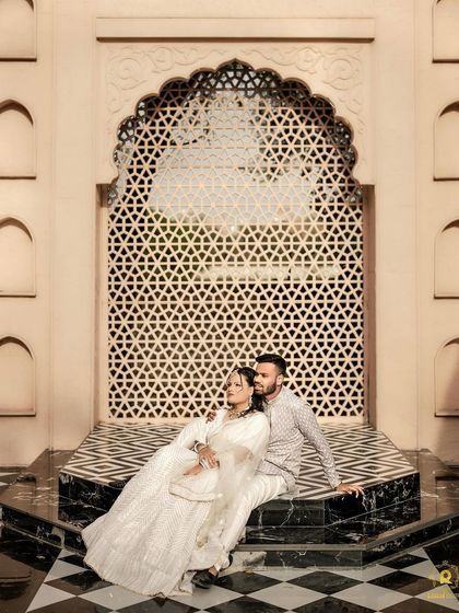 A stunning full-length shot in front of an intricate jaali wall. The makeup is kept clean and radiant to complement the grandeur of the setting.