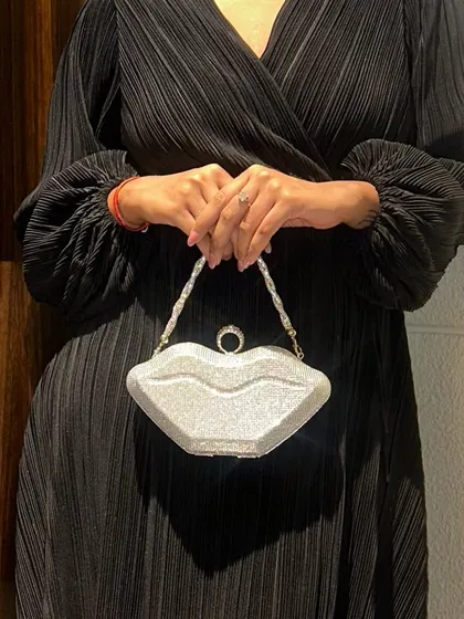 Fashion should be fun, which is why I created this quirky, lip-shaped party clutch. Covered in silver glitter with a delicate pearl handle, it’s a playful and glamorous accessory designed to be a conversation starter on a night out.