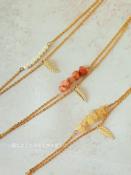 Another view of the elegant layered bracelets, showing the different textures of the smooth pearls and natural stones against the gold chains.