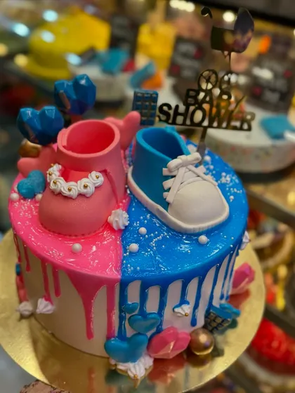 This adorable baby shower cake is perfect for a gender reveal party. It's split into pink and blue themes, decorated with tiny fondant baby shoes and a 'Baby Shower' topper.