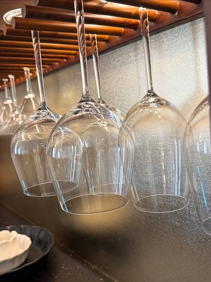 Another detail of the hanging glass rack, showing how it is both a practical storage solution and a beautiful design element that complements the wooden bar unit.