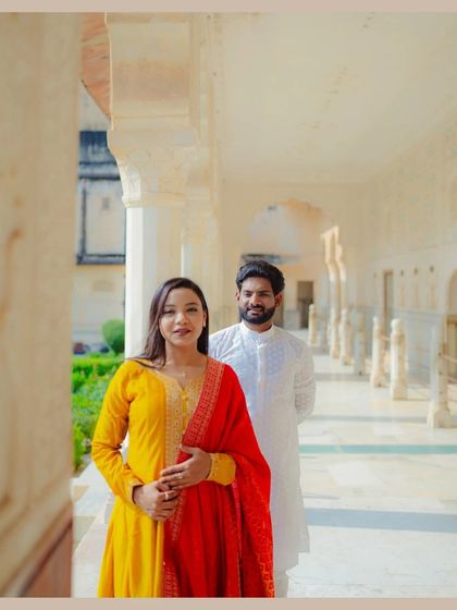 A classic portrait taken in the beautiful corridors of an Udaipur palace. The soft light and repeating arches create a stunning backdrop, highlighting the couple's elegant traditional wear during their destination pre-wedding shoot.