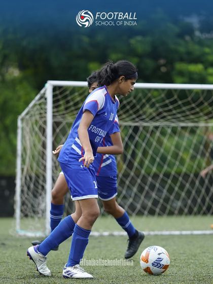A young female player dribbles with determination, showcasing the focus and skill we instill in our dedicated girls' program.