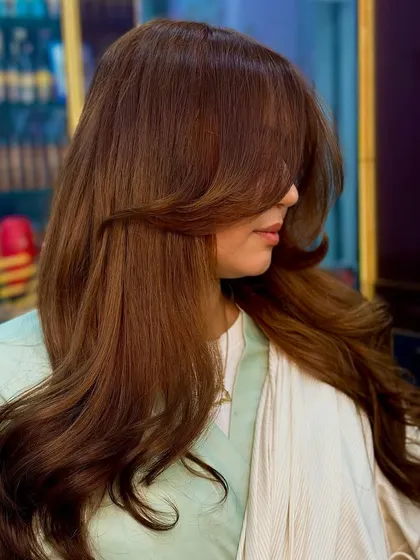 A beautiful side profile with face framing layers that complement the rich chocolate brown color.