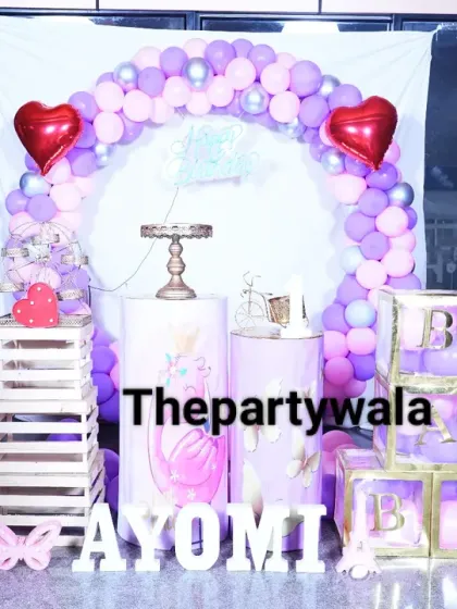 A princess theme featuring two different princesses and heart-shaped foil balloons. The purple and pink balloon arch is decorated with silver accents for a touch of sparkle.