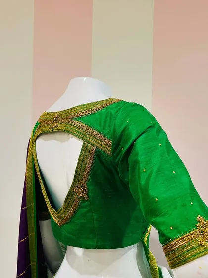 The elegance of a Mysore Silk Saree paired with an intricately hand-embroidered green blouse with a unique geometric back cutout.