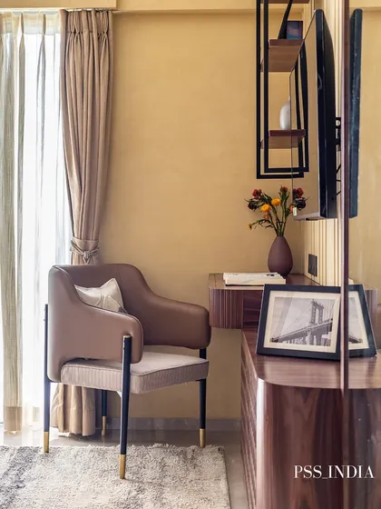 Another angle of the sophisticated study nook, highlighting the comfortable armchair and the natural light from the window, making it a pleasant place to work or read.
