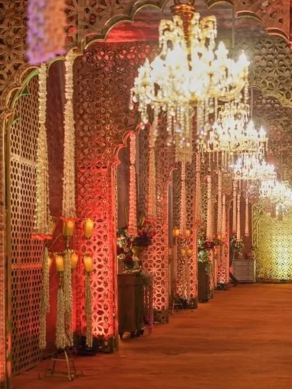An entrance should be the start of the story. I designed this royal walkway with gilded jali panels, glittering chandeliers, and cascading floral garlands to give guests the feeling of stepping into a modern-day palace.