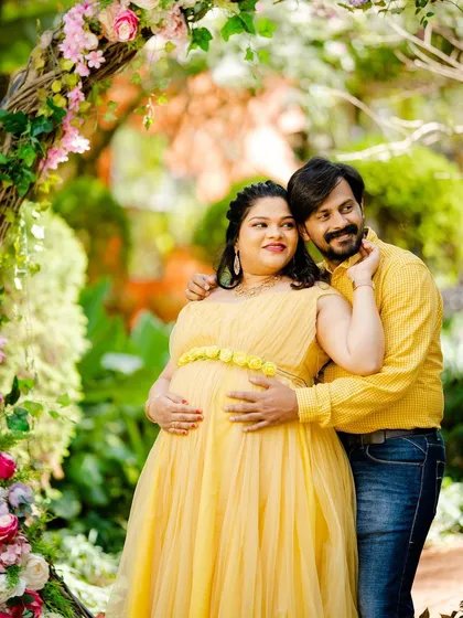A sweet maternity moment for a couple by the floral arch.