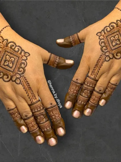 This stylish design features a geometric motif as a centerpiece on the back of the hand. It's a great option for someone looking for a modern yet traditional henna design for an engagement or sangeet.