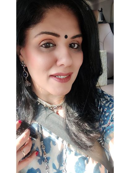 A sun-kissed selfie showing the details of the layered silver jewelry. The blue stone in the long necklace and the silver choker work together to create a cohesive, stylish look.