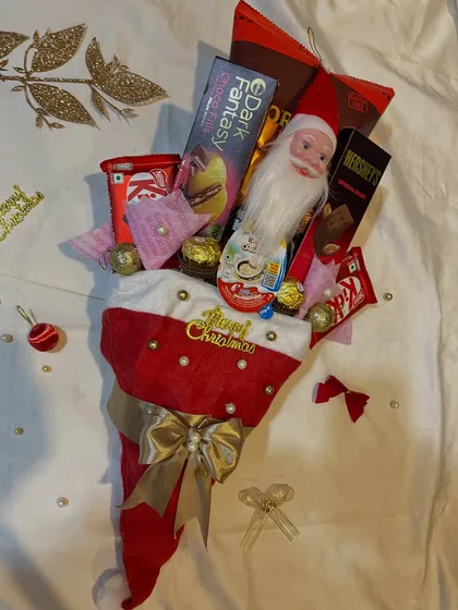 A full shot of the Christmas stocking bouquet, surrounded by festive decorations. It's a creative alternative to a traditional gift basket.