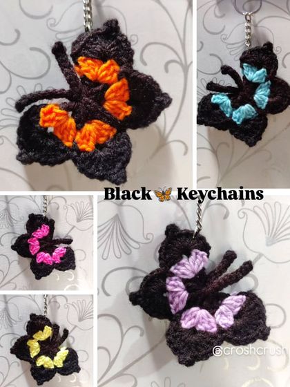 Elegant black butterfly keychains with pops of color like orange, blue, pink, purple, and yellow on the wings.