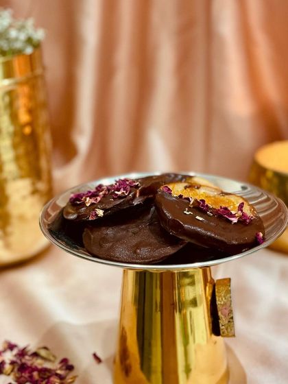 My Chocolate Naarangi, a perfect treat for Diwali. These are chocolate discs topped with candied orange peel and rose petals, offering a festive blend of citrus and floral notes.