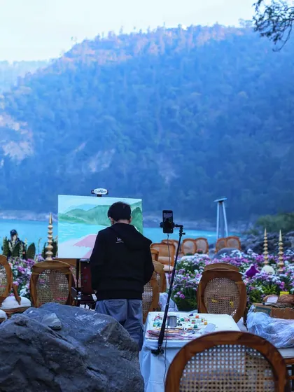 Vivek painting by the riverside in Rishikesh. The tranquil environment and the sound of the water made this a serene painting experience.