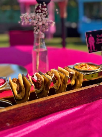 A platter of 'Tug of Dropkicks' tacos lined up and ready to be served. The presentation in a custom wooden holder with accompanying dips shows my attention to both taste and visual appeal.
