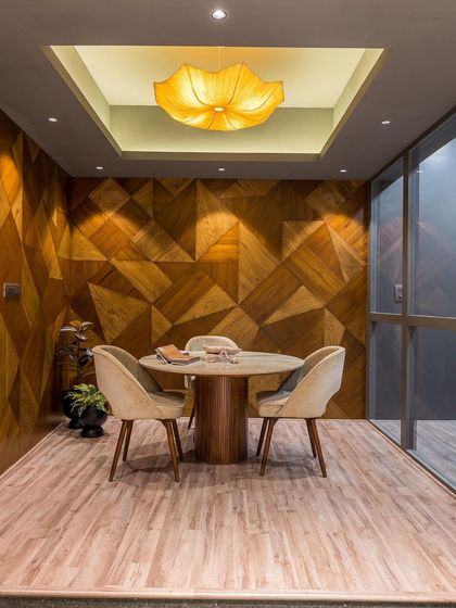 The full view of the discussion room, with its stunning veneer walls, elegant furniture, and a beautiful lotus-shaped light fixture.