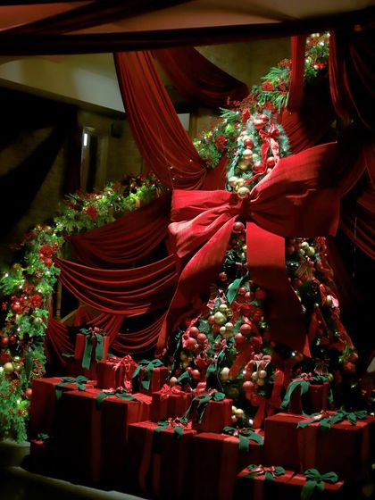 The grand Christmas tree setup at Gigi, surrounded by red drapery and a mountain of presents.