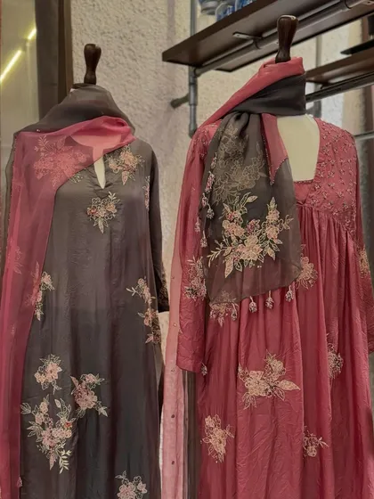 The two Kora outfits displayed together, showcasing a sophisticated and romantic color palette of grey and pink.