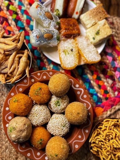 A colourful platter of our diverse offerings, from different types of laddoos to classic barfis and namkeen. This shows the variety you can include in your custom gift hampers.