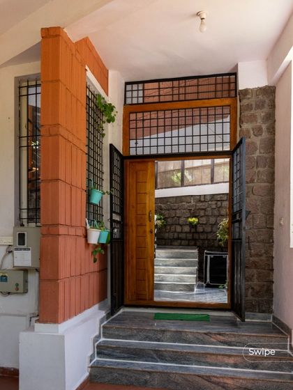 The entryway of the Gifty Residence showcases a mix of materials: terracotta, stone, wood, and steel. This layered approach creates visual interest and sets the tone for the rest of the home.