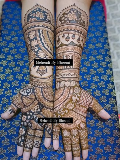 A stunning full-arm design with a mix of everything. It includes a bride in a doli, peacocks, floral patterns, and the initial 'R' hidden in the design.