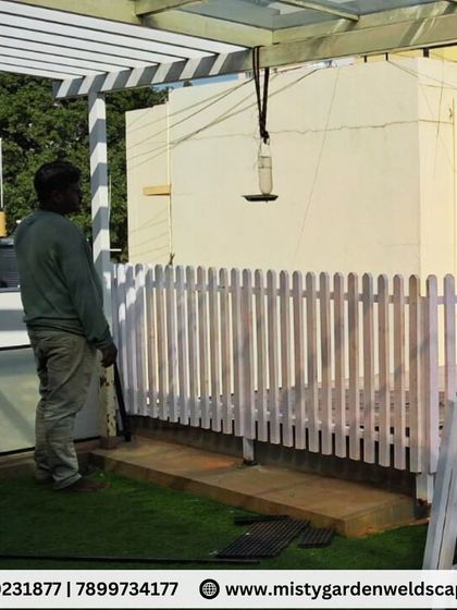 A classic white wooden picket fence adds timeless charm to this terrace garden. It serves to define the space, protect the planters, and enhance the overall aesthetic.