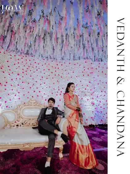 An elegant portrait of a couple seated on a vintage couch against a stunning, floor-to-ceiling backdrop of white and pink flowers. This shot demonstrates my eye for composition and ability to capture the grandeur of a beautifully styled wedding reception.
