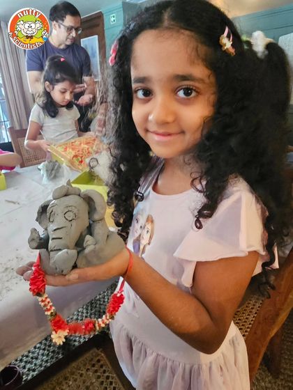 The pride of creation! This young artist is all smiles with her completed Tree Ganesha, made from natural Shadu Mitti clay that will return to the earth after the festivities.
