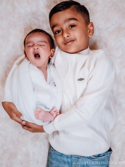 A sleepy yawn from the little one. I love capturing these authentic interactions during a sibling photoshoot, showing the dynamic between the two.