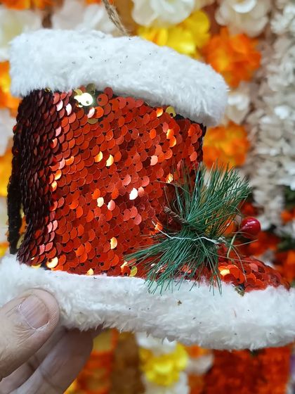 A festive, sequined red Santa boot ornament. This sparkly decoration adds a touch of glamour to any Christmas tree and is part of our extensive collection of unique tree hangings.