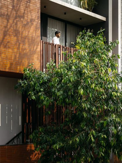 The balcony of the 'Ittige' residence acts as a threshold between the interior and the exterior. The screen provides privacy and shade without disconnecting the inhabitant from the sights and sounds of the neighborhood.