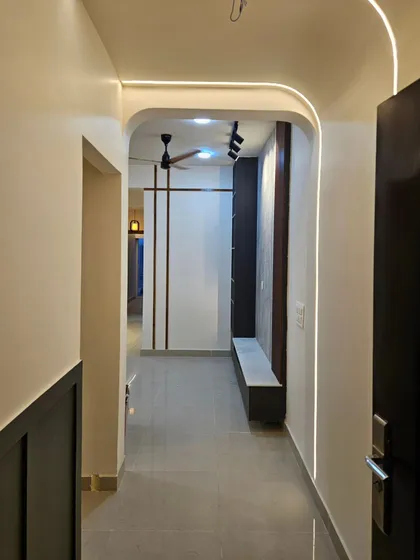 This entryway was designed to be both beautiful and functional. I created an archway with profile lighting to lead into the main living area, where a sleek seating bench and storage unit greet you.