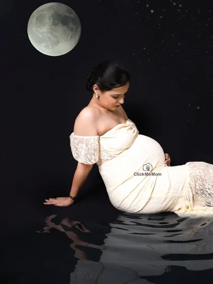 A celestial dream by the water. This composite image places the mom-to-be under a full moon with her reflection in the water, creating a serene, magical, and otherworldly maternity portrait.